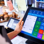 POS system touchscreen used by a café employee to process payments