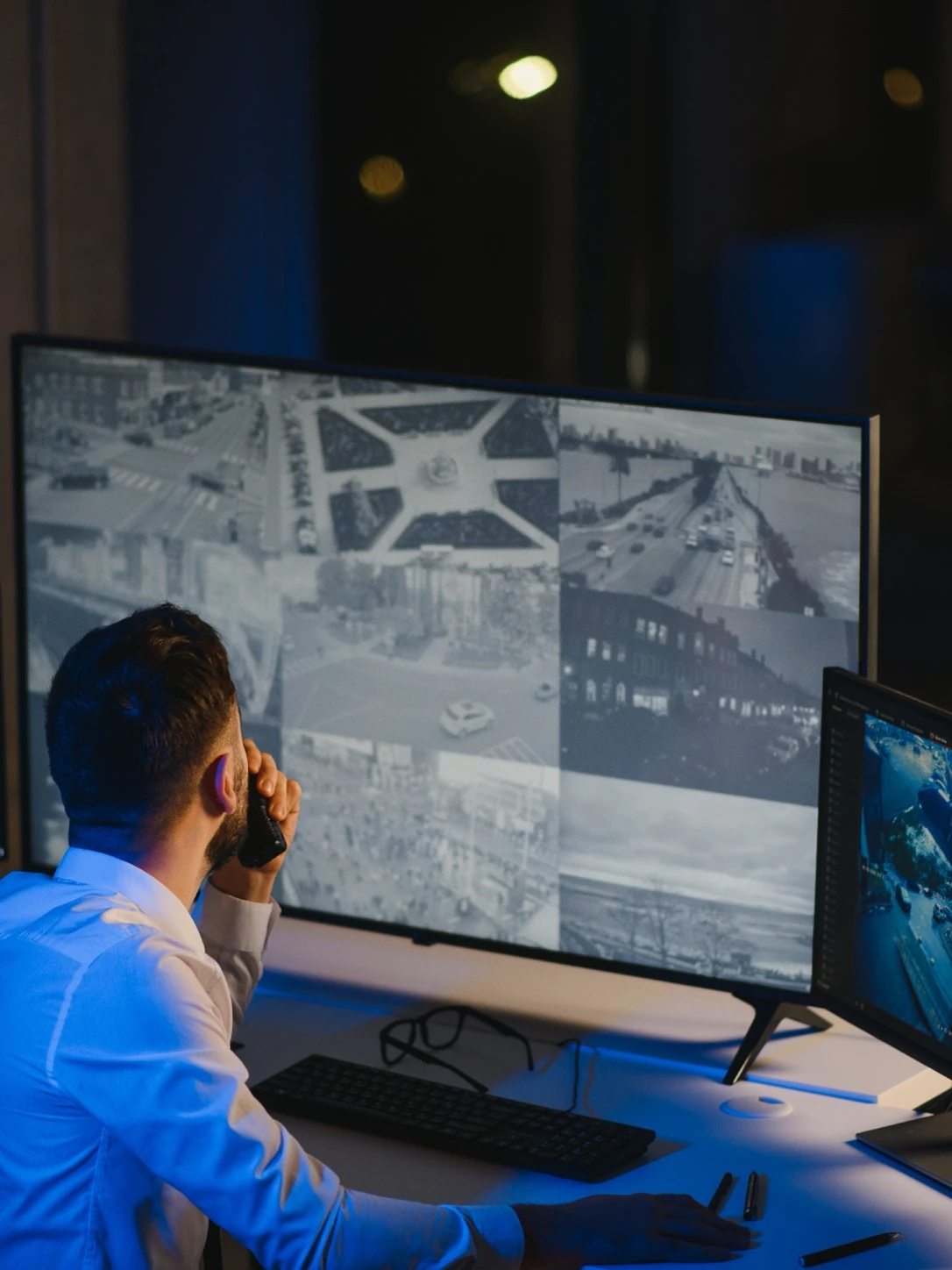 Security operator monitoring multiple CCTV surveillance cameras in a control room
